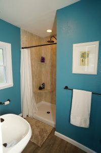 Bathroom with a walk-in shower and teal walls.