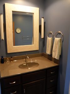 View of bathroom with granite sink counter, gray walls, and large mirror.