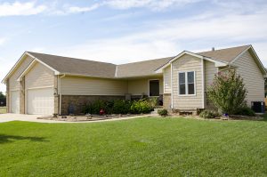 Single family home featuring beige siding and a well manicured lawn.