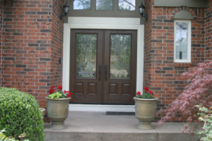 Residential home featuring brown double front doors with window panes.