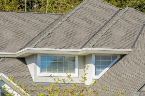 The roof of the house with nice window and white frame.